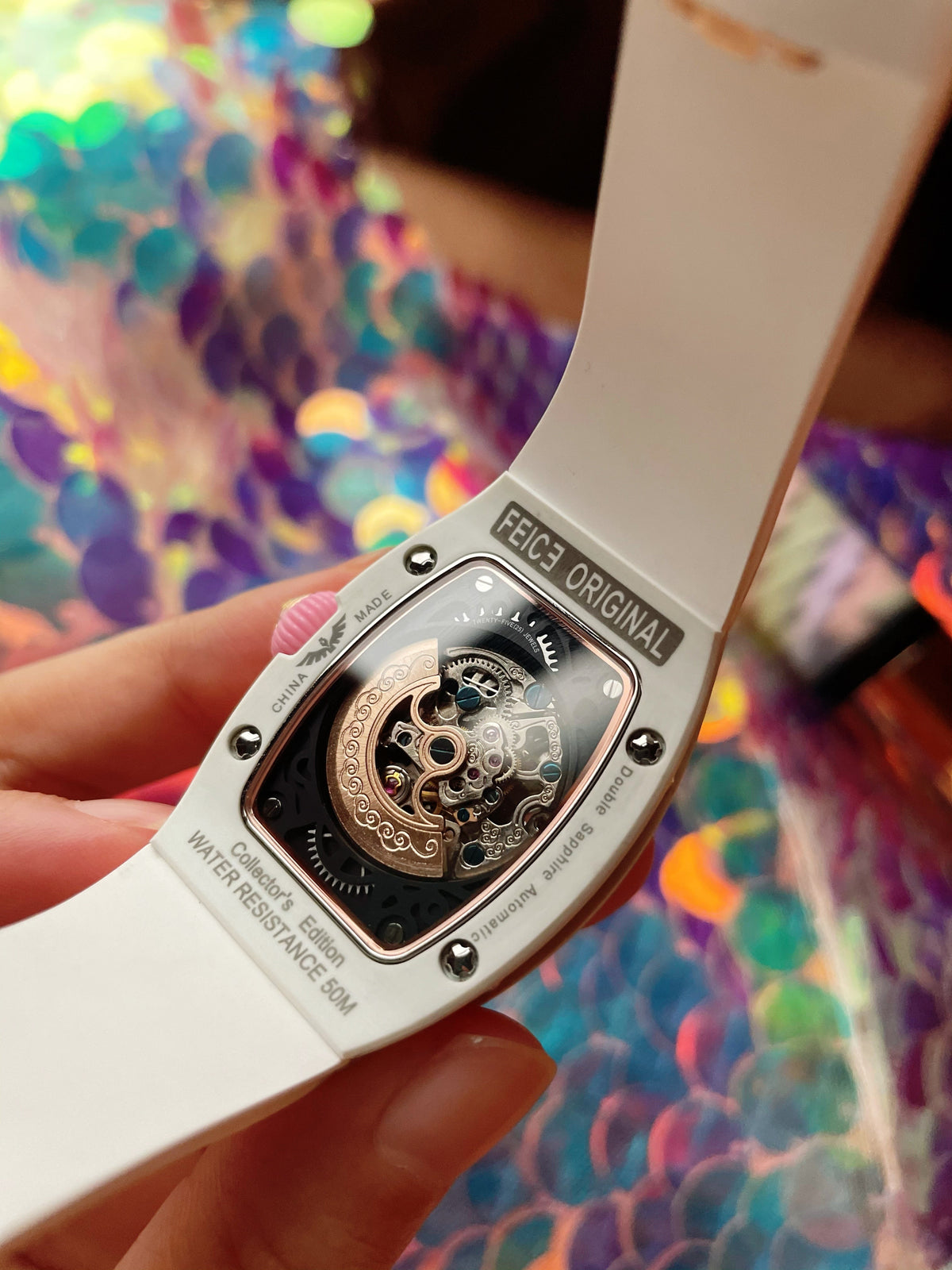 White luxury chronograph watch with transparent skeleton automatic movement and sapphire case back.