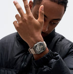 Luxury skeleton watch with carbon fiber case, bold motorsport design, and beige strap on wrist