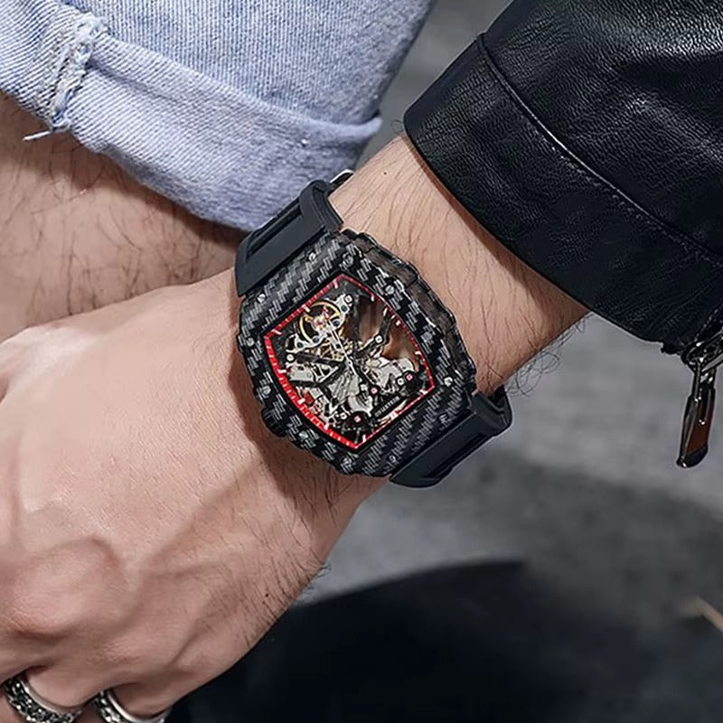 Luxury carbon fiber skeleton chronograph watch with racing-inspired red accents on a wrist.
