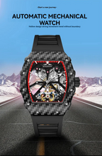 Automatic mechanical skeleton watch with carbon fiber case and red accents on a mountain road.