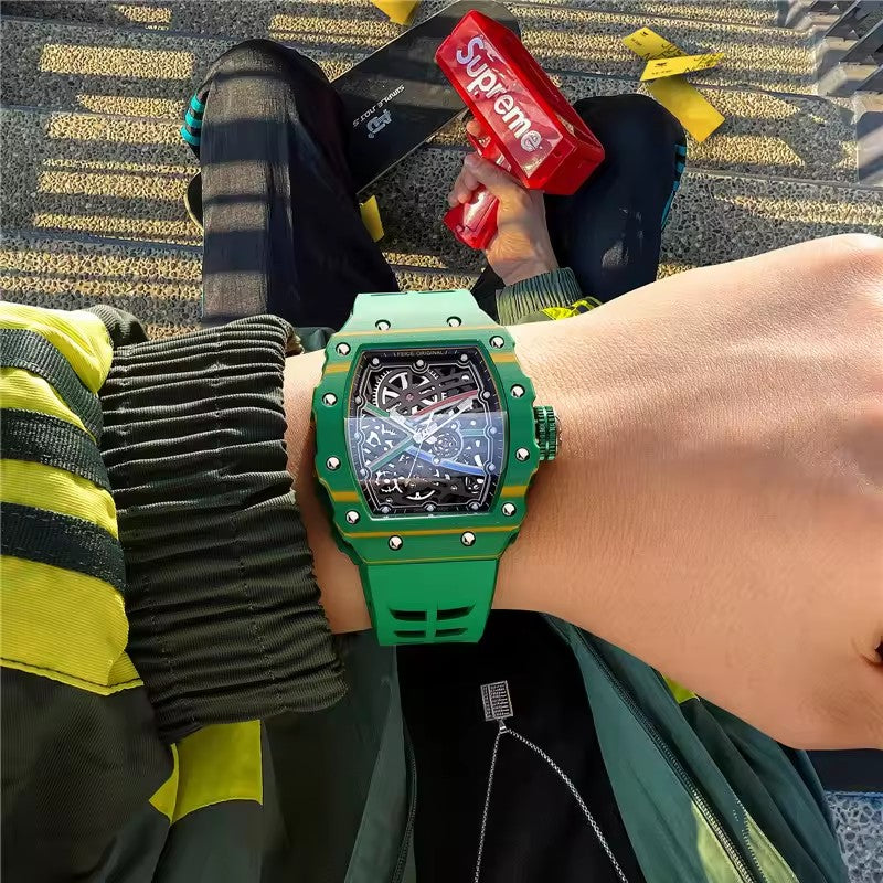 Green luxury racing chronograph watch with skeleton dial and rubber strap on a wrist.